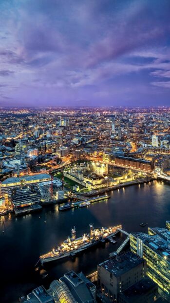 The aerial view captures the illuminated cityscape of the United Kingdom with historical buildings and waterways at dusk, HD Mobile Wallpaper