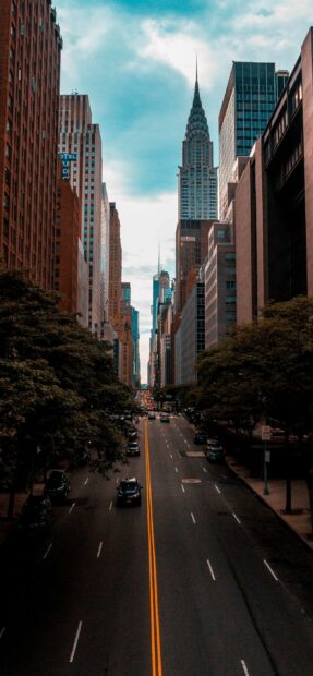 A vibrant street view in the United States with tall buildings and the iconic Chrysler building in the background