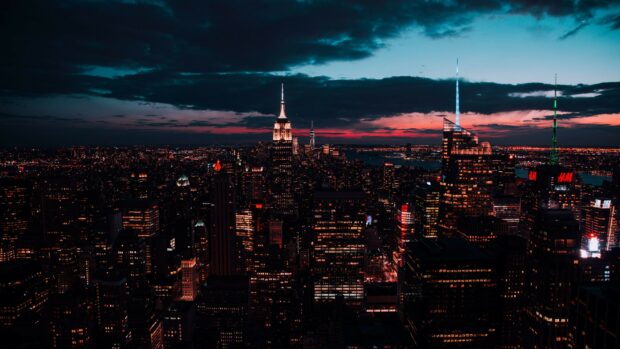 Nighttime cityscape of United States skyline with illuminated skyscrapers and a dark blue sky