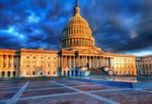 The United States Capitol building illuminated by sunset light with dramatic cloudy sky