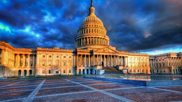 The United States Capitol building illuminated by sunset light with dramatic cloudy sky