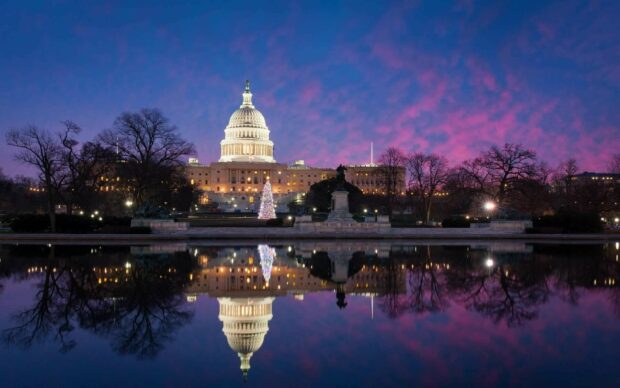 The United States Capitol building reflected in water during sunset United States