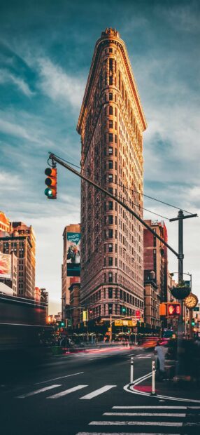 The flatiron building is captured with warm sunlight lighting in the United States cityscape