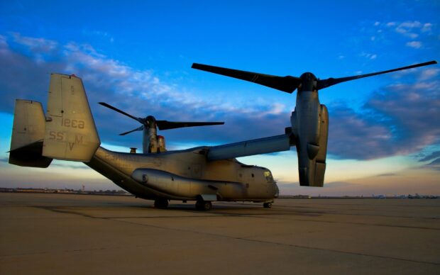 Military aircraft V 22 Osprey on the runway under a vibrant evening sky