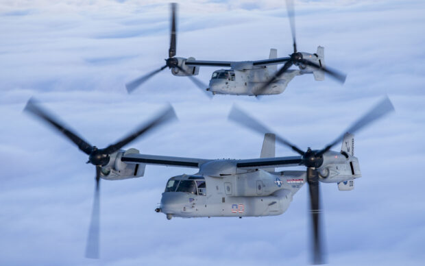 Two V 22 Osprey aircraft flying above clouds in clear sky