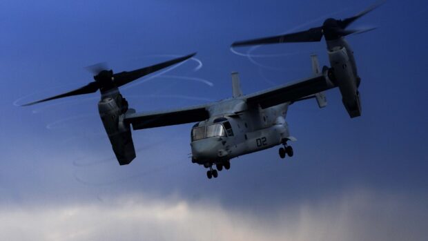 V 22 Osprey in flight during twilight sky with visible rotor motion blades