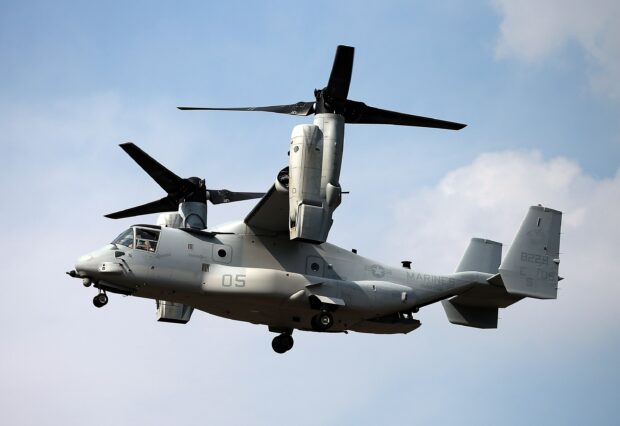 V 22 Osprey tiltrotor aircraft flying in the sky with its rotors in vertical position