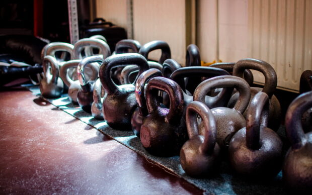 A row of kettlebells lined up on the gym floor for crossfit workouts, HD Desktop Wallpaper