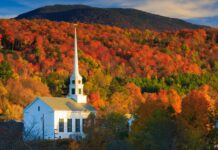 A white church steeple stands against vibrant fall foliage in Vermont, 2K Desktop Wallpaper