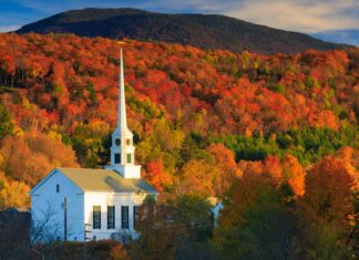 A white church steeple stands against vibrant fall foliage in Vermont, 2K Desktop Wallpaper