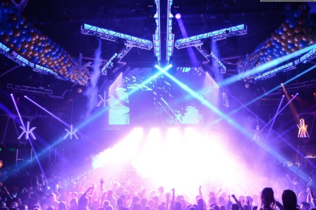 A lively nightclub features bright lights and a cheering crowd, 2K Desktop Wallpaper