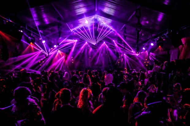 A crowded nightclub scene with vibrant lighting and people dancing, HD Desktop Wallpaper