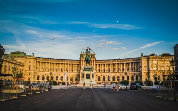 The historic Hofburg Palace in Vienna Austria with a statue in front under a clear blue sky
