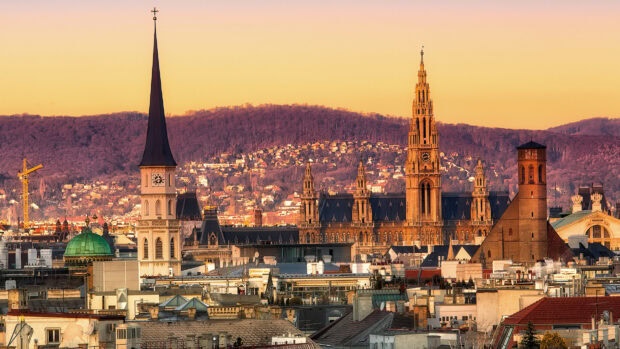 Historic Vienna Austria skyline with clock towers and hills at sunset