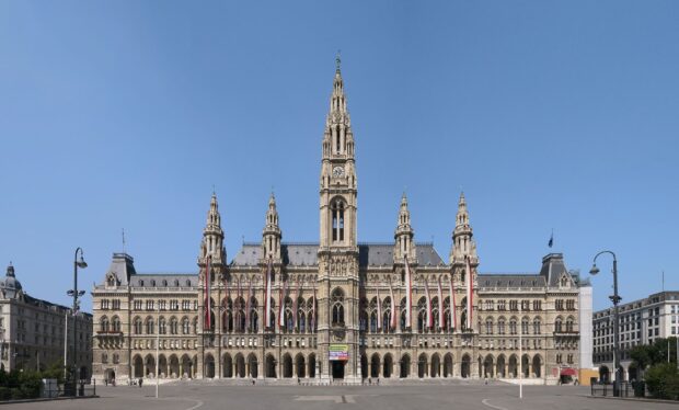 The historic Vienna Austria city hall stands tall under clear blue sky