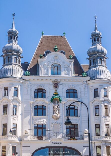 Ornate historical building in Vienna Austria with detailed sculptures and windows under clear blue sky