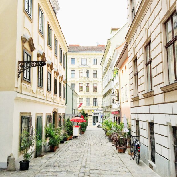 Charming Vienna Austria street with vintage buildings and outdoor seating on a sunny day
