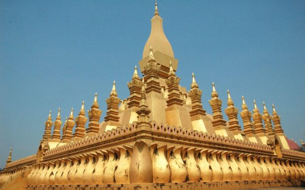 The golden stupa in Vientiane is a famous landmark with intricate details under clear blue sky