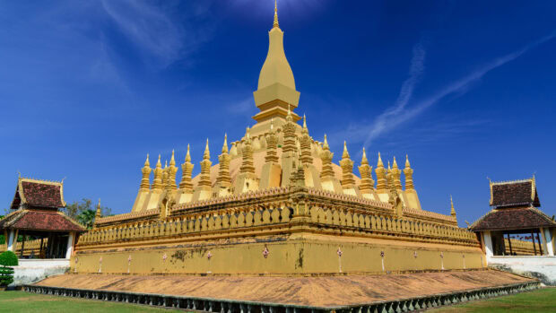 The golden stupa in Vientiane with traditional architecture under a clear blue sky
