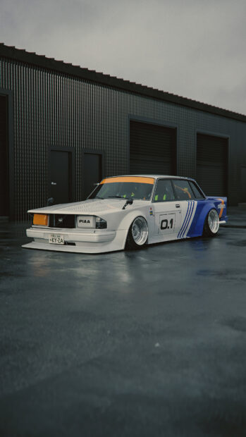 Classic Volvo racing car with white and blue paint parked on wet ground