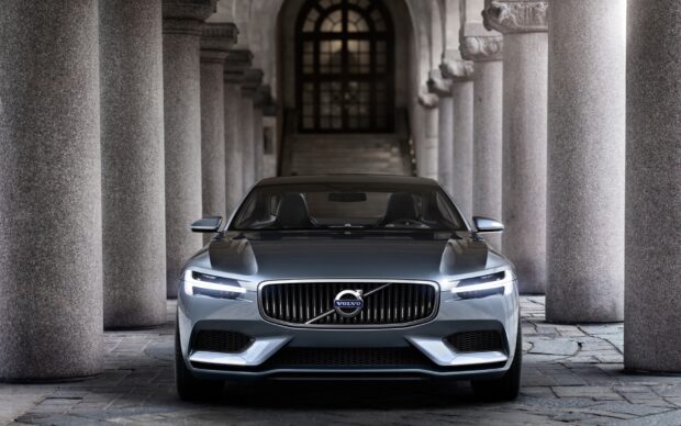 Front view of Volvo car parked between stone columns in a historic building