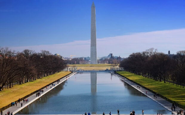 The Washington Monument with its reflection in the National Mall reflecting pool on a clear day