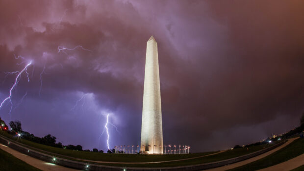 Lightning strikes illuminate the Washington Monument against a stormy sky at night
