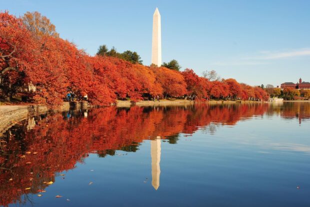 Washington Monument with vibrant autumn trees reflecting in the water