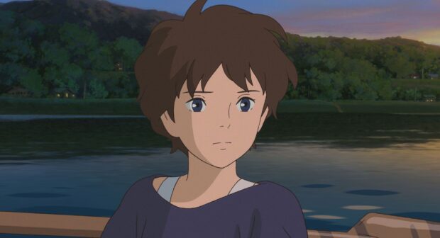 A thoughtful character from When Marnie Was There sitting by a river at dusk surrounded by trees