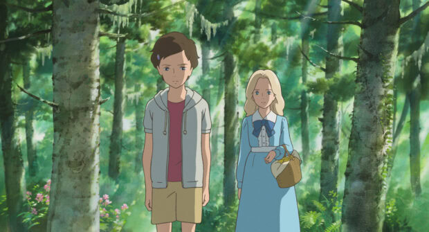 Two characters from When Marnie Was There stand in a lush forest filled with tall trees and greenery