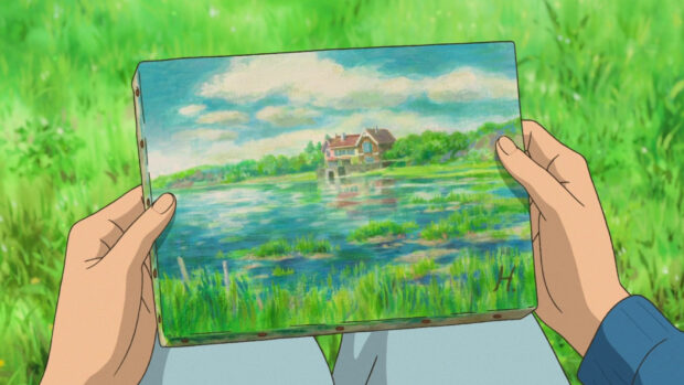 A hand holding a painting of a lake house in the anime When Marnie Was There