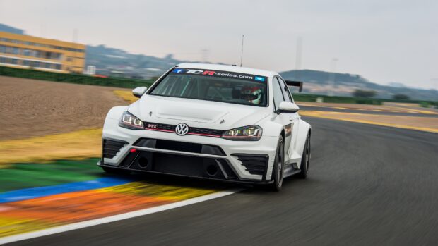 A white Volkswagen Golf GTI car is speeding around a colorful racetrack curve in this action shot, 4K Desktop Wallpaper