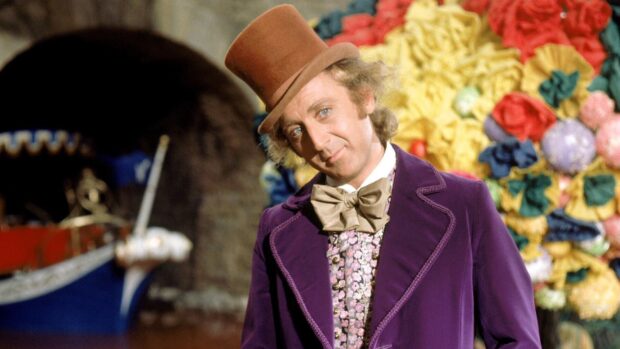 Willy Wonka character wearing a purple coat and brown top hat in a colorful setting