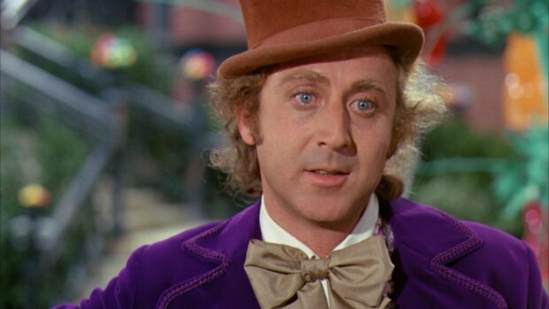 Willy Wonka character wearing a purple coat and brown top hat with a bow tie in a colorful setting