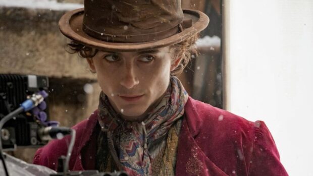Willy Wonka wearing a brown hat and colorful scarf in a vintage setting
