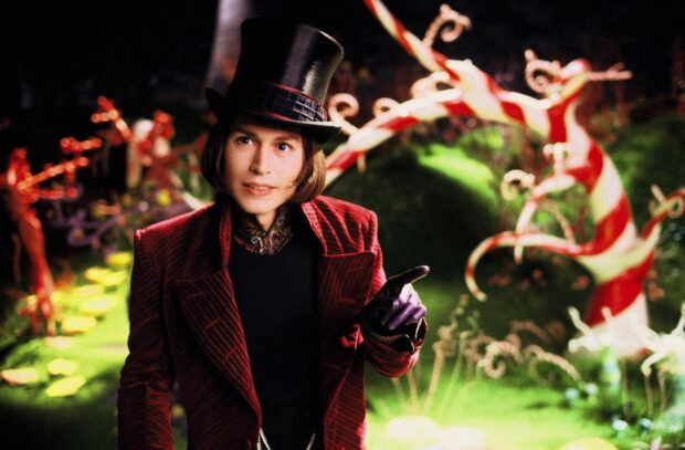 Willy Wonka wearing a top hat and red velvet coat standing in a colorful fantasy garden