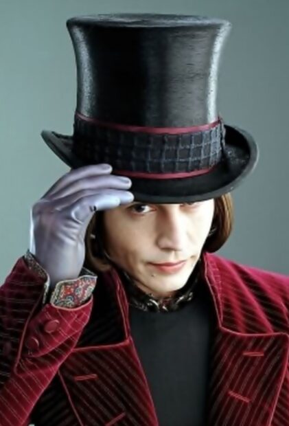 A close up of Willy Wonka wearing a top hat and purple glove