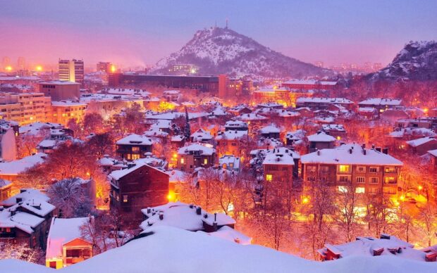 A snowy Bulgaria cityscape highlights warm lights under a purple sky in this Bulgaria Wallpapers, HD Desktop Wallpaper