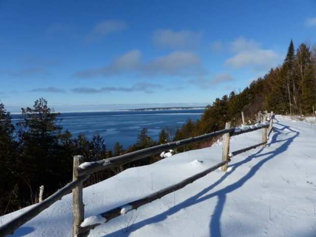 A snowy fence outlines the edge with Mackinac Island wallpapers visible across the icy water, HD Desktop Wallpaper