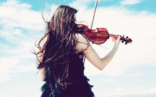 A woman with long hair is playing a violin outdoors with a bright sky background, 2K Desktop Wallpaper