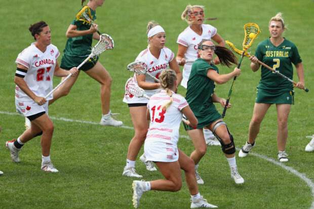 A group of women lacrosse players from Canada and Australia competing intensely on the grass field, HD Desktop Wallpaper
