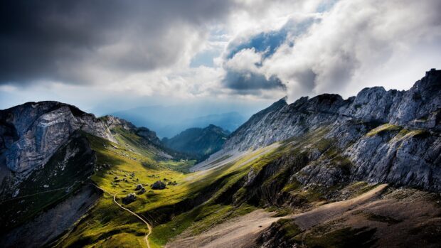 Scenic Wyoming valley with mountain peaks and cloudy sky under sunlight rays