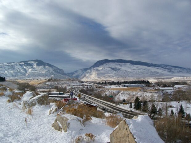 Snow covered landscape with Wyoming mountains and highway in winter scenery
