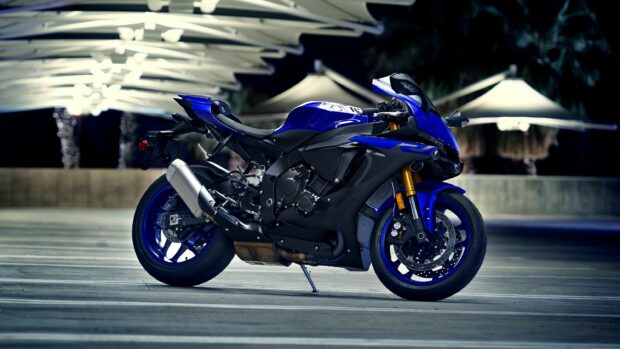 Blue Yamaha sport motorcycle parked in a modern outdoor setting at night