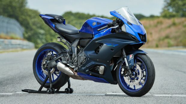Blue Yamaha motorcycle parked on racetrack with clear background