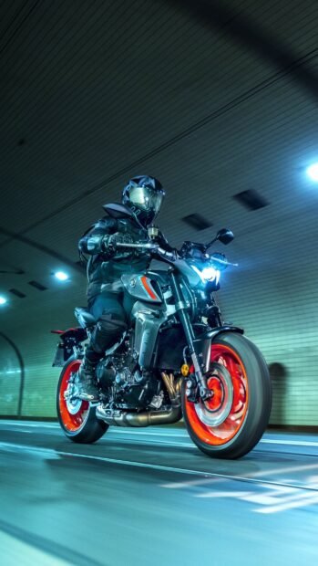 A rider wearing protective gear on a Yamaha motorcycle riding through a tunnel at night