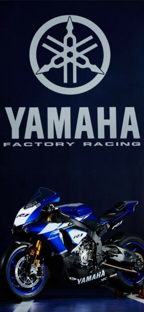 High quality Yamaha motorcycle parked under Yamaha Factory Racing logo on dark background