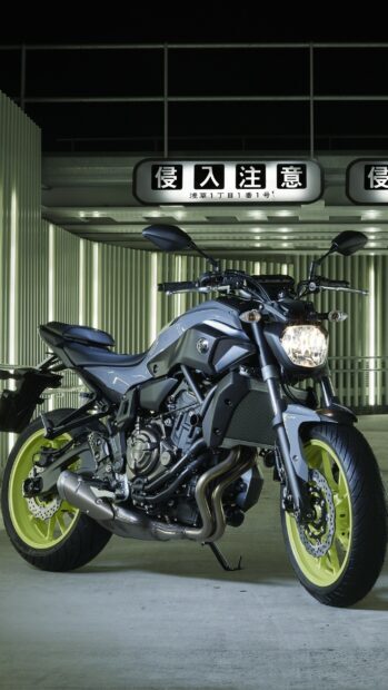 Yamaha motorcycle parked in a lit urban area at night with bright yellow wheels