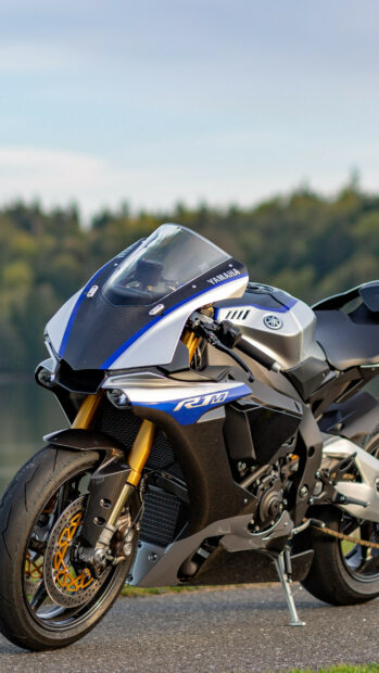 A Yamaha sport motorcycle parked on the road with a forest background