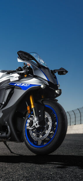Close up of Yamaha sport motorcycle front wheel and fairing on racetrack